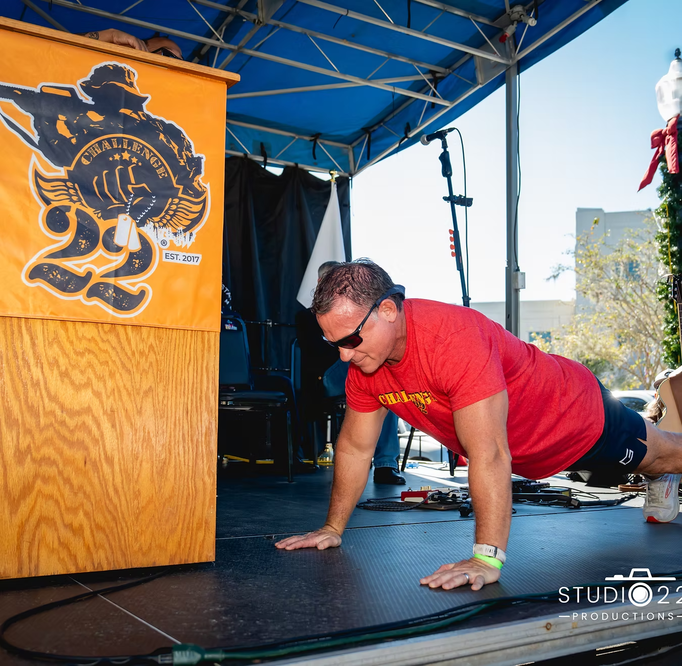 A Challenge 22 supporter doing push-ups on stage